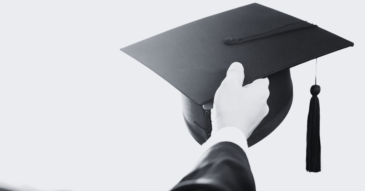 Black and white photograph of a hand holding up a black graduation cap to illustrate how important 529 plans can be.