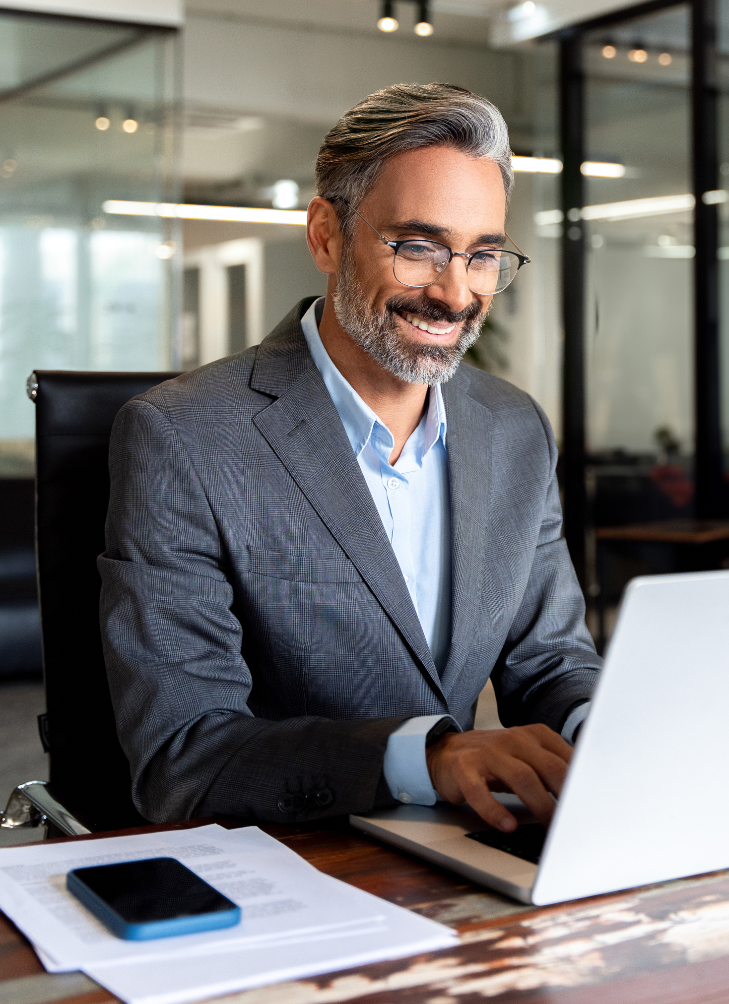 Man in 50s sitting at a laptop to illustrate the demographic of retirement planning for MedTech services